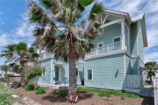 exterior space featuring covered porch and a balcony