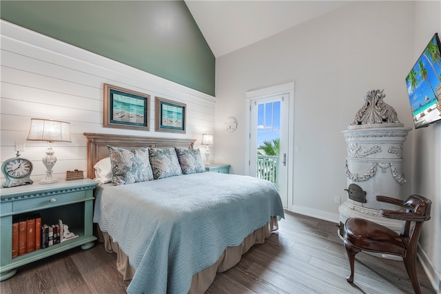 bedroom featuring dark wood-type flooring, access to outside, and lofted ceiling