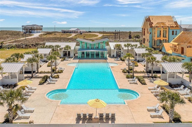 view of swimming pool featuring a water view and a patio area