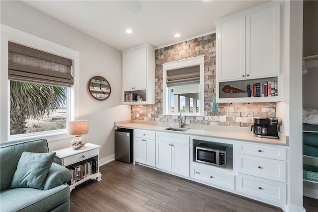 kitchen with white cabinets, appliances with stainless steel finishes, dark hardwood / wood-style floors, and sink