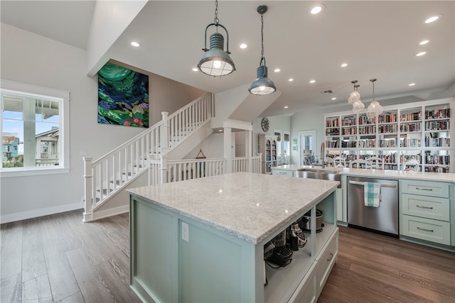 kitchen featuring dark wood-type flooring, a center island, stainless steel dishwasher, light stone countertops, and pendant lighting