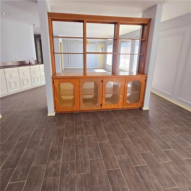 spare room featuring wood finish floors, a sink, and a decorative wall