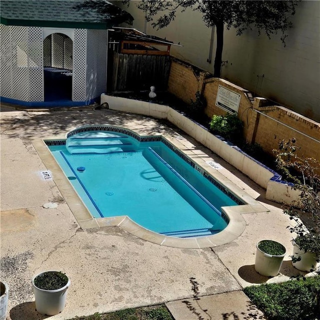 view of pool featuring fence and a pool