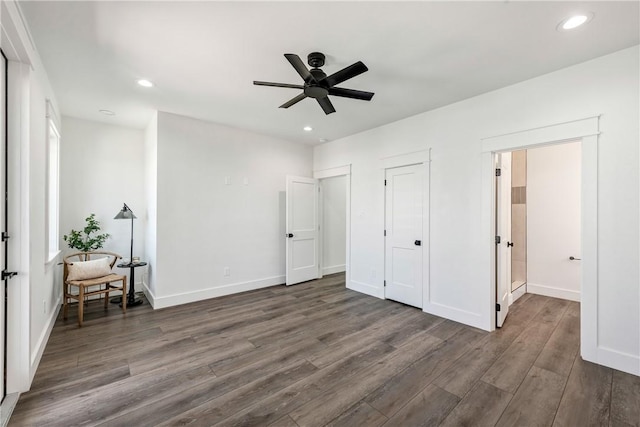 unfurnished bedroom featuring ceiling fan and dark hardwood / wood-style flooring