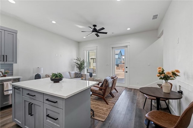 kitchen with ceiling fan, a center island, gray cabinetry, and dark wood-type flooring