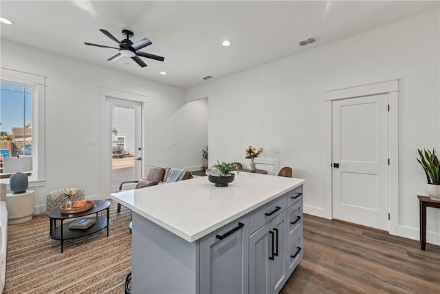 kitchen featuring a center island, dark wood-type flooring, ceiling fan, and gray cabinetry