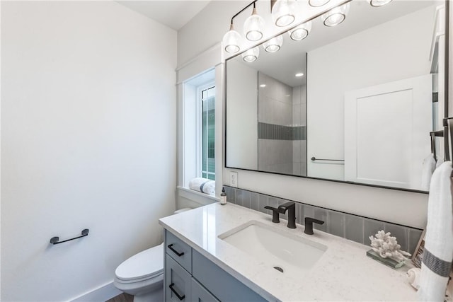 bathroom with vanity, a shower, and toilet