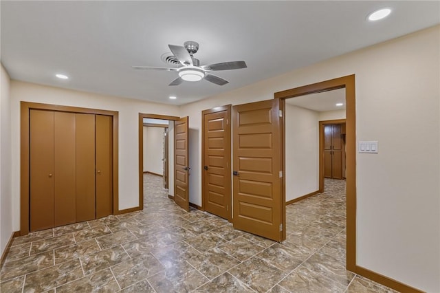 unfurnished bedroom featuring multiple closets and ceiling fan