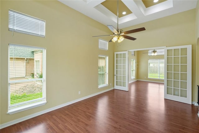 7445 Lake Micala Dr, Corpus Christi, TX 78413 - unfurnished room featuring a towering ceiling, wood finished floors, coffered ceiling, healthy amount of natural light, and a ceiling fan