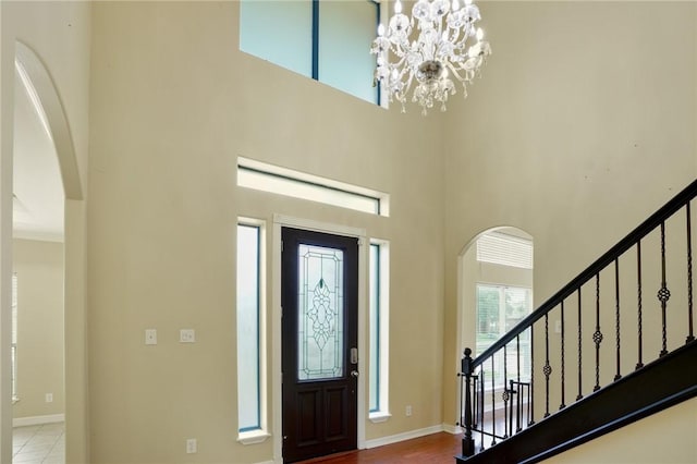 7445 Lake Micala Dr, Corpus Christi, TX 78413 - foyer with arched walkways, a towering ceiling, a chandelier, and stairs