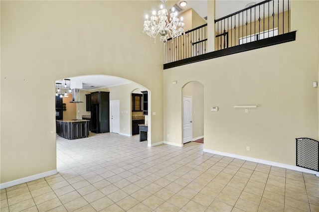 7445 Lake Micala Dr, Corpus Christi, TX 78413 - unfurnished living room with arched walkways, a chandelier, a high ceiling, and light tile patterned flooring