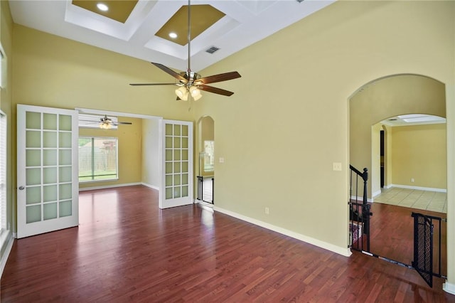 7445 Lake Micala Dr, Corpus Christi, TX 78413 - unfurnished room with arched walkways, wood finished floors, coffered ceiling, a high ceiling, and beam ceiling