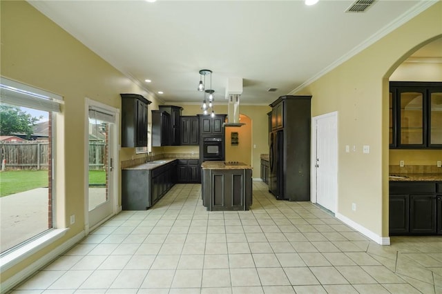 7445 Lake Micala Dr, Corpus Christi, TX 78413 - kitchen with black appliances, arched walkways, island exhaust hood, ornamental molding, and light tile patterned floors