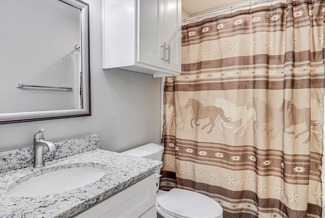 bathroom featuring a shower with shower curtain, vanity, and toilet