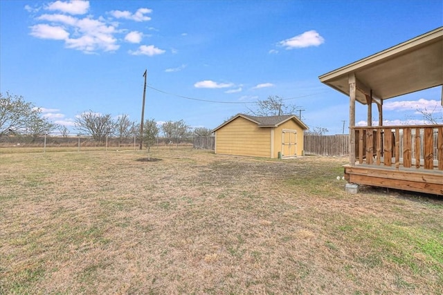 view of yard featuring a storage shed, a fenced backyard, and an outdoor structure