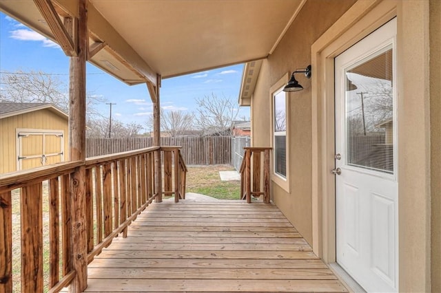 wooden deck with a fenced backyard and an outbuilding