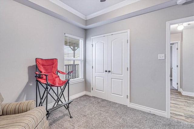 sitting room featuring carpet floors, baseboards, and crown molding