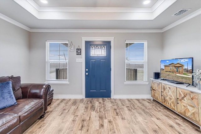 foyer featuring a tray ceiling, visible vents, and light wood-style flooring