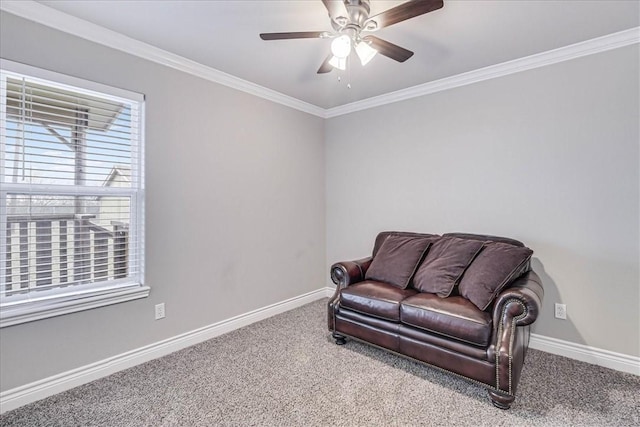 sitting room featuring carpet, baseboards, a ceiling fan, and ornamental molding