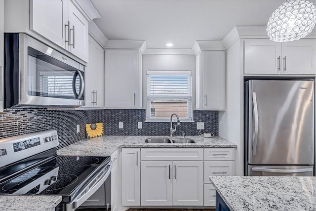 kitchen featuring stainless steel appliances, backsplash, white cabinets, a sink, and light stone countertops