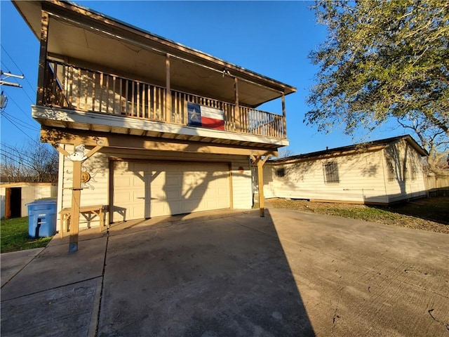 view of front of house featuring concrete driveway, a balcony, and an attached garage