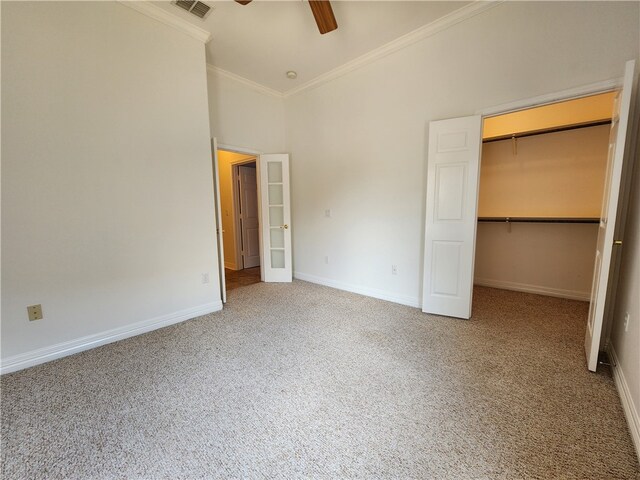 unfurnished bedroom featuring lofted ceiling, carpet flooring, ornamental molding, a spacious closet, and a closet