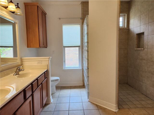 bathroom with vanity, tile patterned floors, toilet, and tiled shower