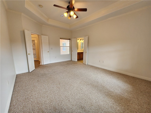 unfurnished bedroom with crown molding, ceiling fan, carpet, connected bathroom, and a raised ceiling