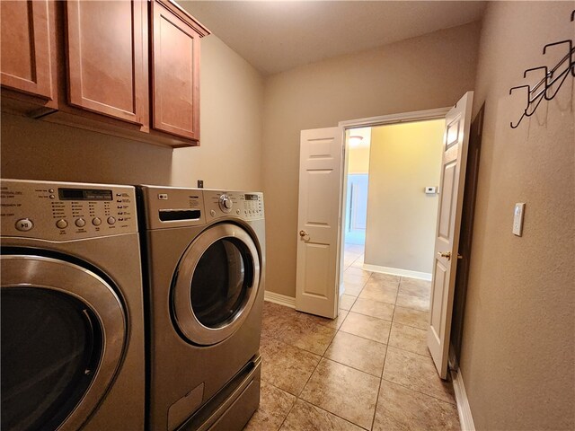 laundry room featuring cabinets, washing machine and dryer, and light tile patterned floors