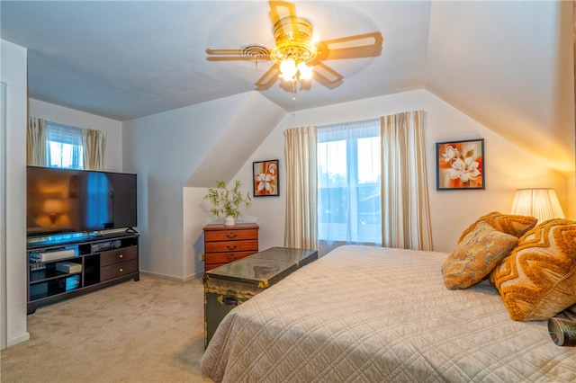 bedroom with ceiling fan, light colored carpet, and vaulted ceiling