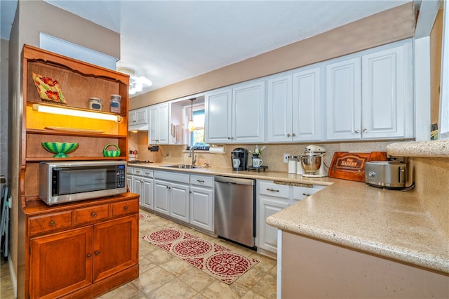 kitchen featuring backsplash, sink, white cabinets, and appliances with stainless steel finishes