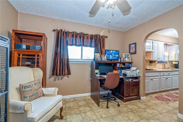 office space with a textured ceiling, ceiling fan, and sink