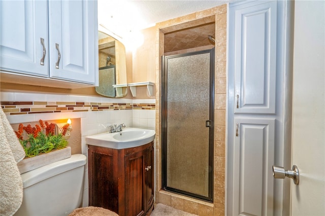 bathroom featuring vanity, toilet, walk in shower, and tile walls