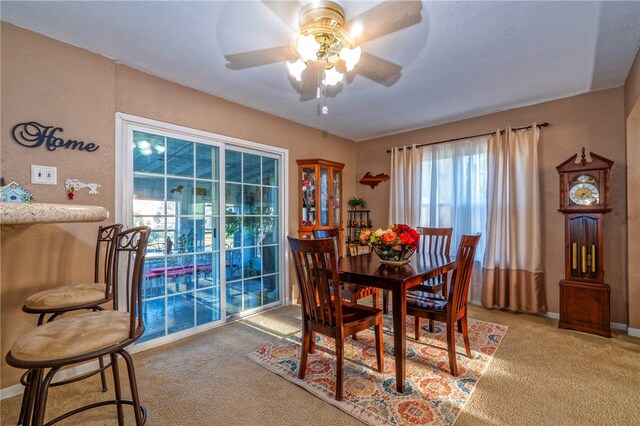 carpeted dining area featuring ceiling fan