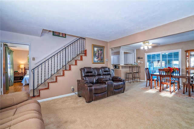 carpeted living room with ceiling fan and a textured ceiling