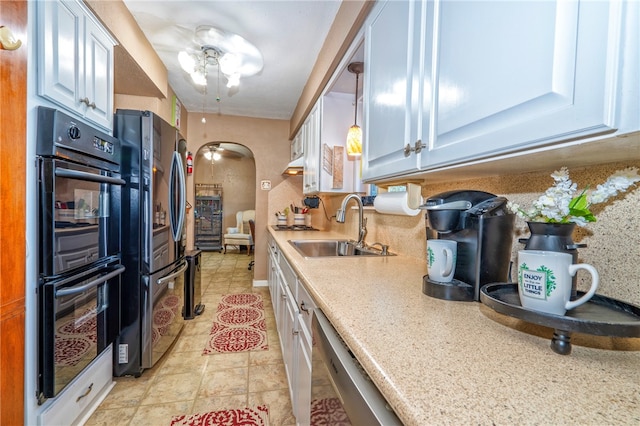 kitchen with sink, hanging light fixtures, ceiling fan, appliances with stainless steel finishes, and white cabinetry