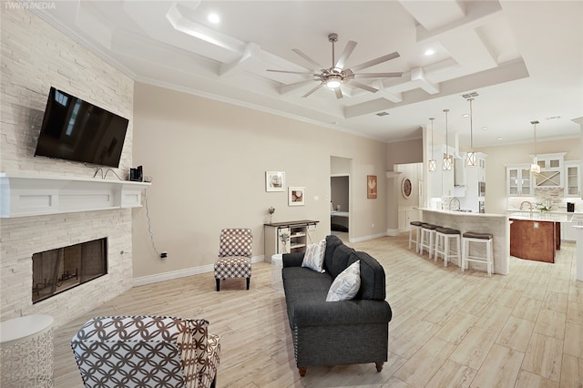 6701 Paddington Dr, Corpus Christi, TX 78414 - living area with baseboards, a stone fireplace, a ceiling fan, crown molding, and light wood-style flooring