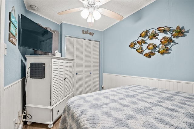 bedroom featuring wood-type flooring, ceiling fan, crown molding, a textured ceiling, and a closet