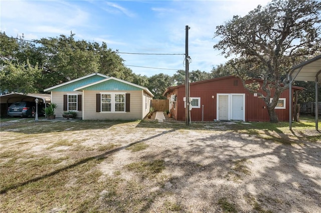 exterior space with an outbuilding, a front lawn, a carport, and fence