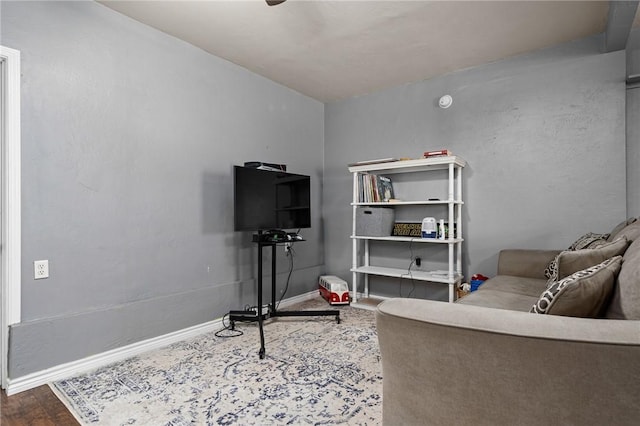 living area featuring baseboards and wood finished floors