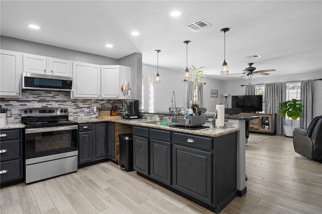 kitchen with white cabinetry, visible vents, appliances with stainless steel finishes, and open floor plan