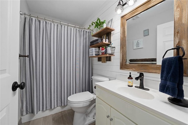 bathroom featuring wood walls, vanity, visible vents, a shower with shower curtain, and toilet