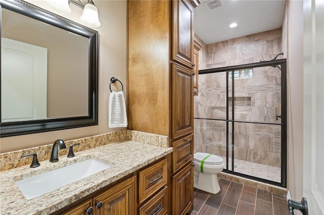 full bathroom with a stall shower, vanity, toilet, visible vents, and recessed lighting