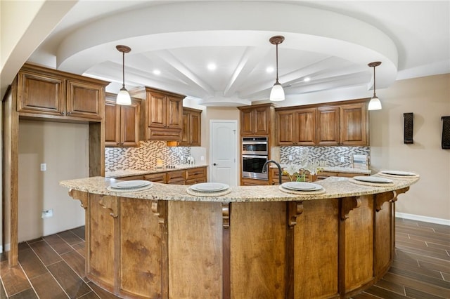 kitchen with brown cabinetry, wood finish floors, stainless steel double oven, and beam ceiling
