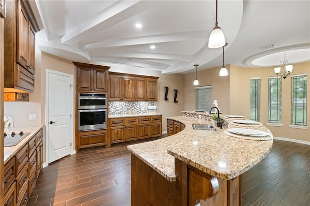 kitchen featuring black electric stovetop, dark wood-style flooring, stainless steel double oven, and a sink