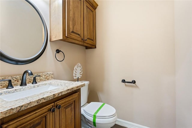 half bathroom featuring vanity and toilet