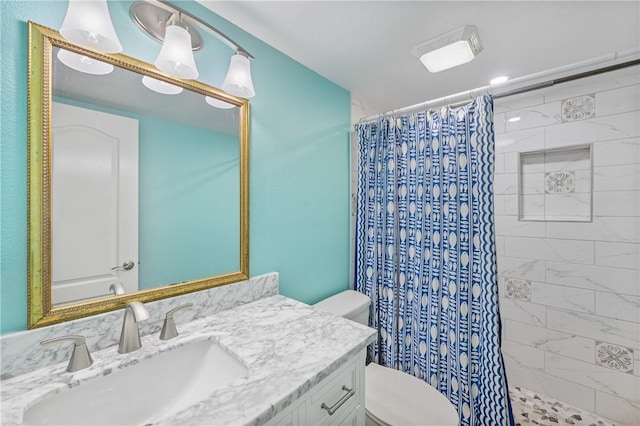 bathroom featuring toilet, a tile shower, and vanity