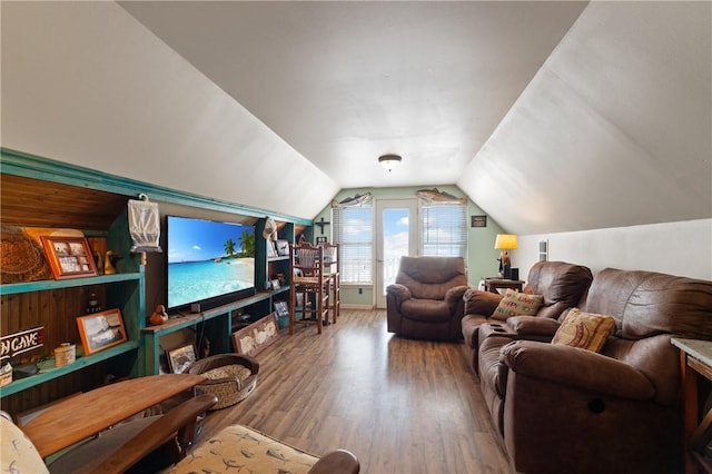 living area with wood finished floors, lofted ceiling, and baseboards