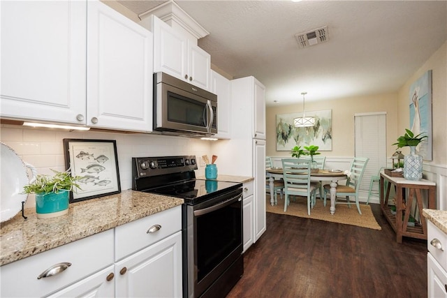 kitchen featuring stainless steel appliances, visible vents, backsplash, dark wood-type flooring, and white cabinets