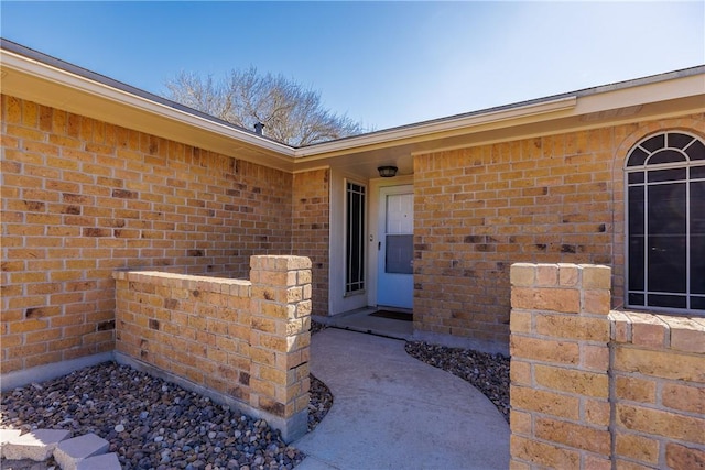 entrance to property featuring brick siding